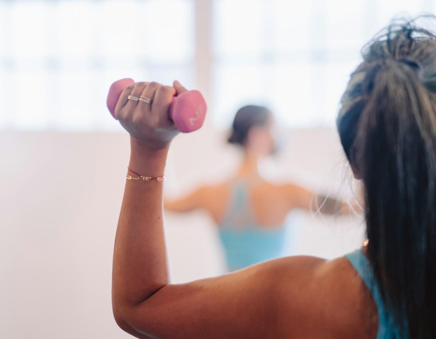 Yoga Kendra Malmö Barre/ Pilates Woman in yoga clothes holding small weights in each hand